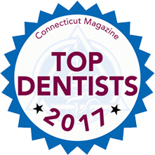 The image shows a badge with text that reads  2017 TOP DENTISTS  and includes a logo for Connecticut Magazine, indicating an award or recognition given by the magazine to dentists in 2017.