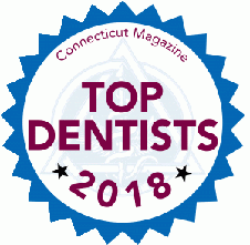 The image features a badge with text that reads  Top Dentists 2018  and includes the logo for Connecticut Magazine, indicating an award or recognition given by the magazine to dentists in the state of Connecticut.