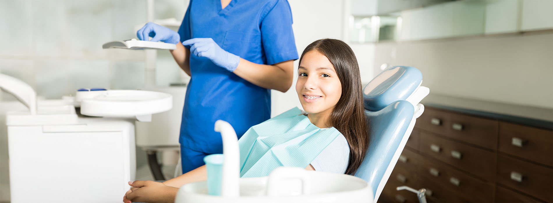 A dental hygienist assisting a patient during a dental examination.